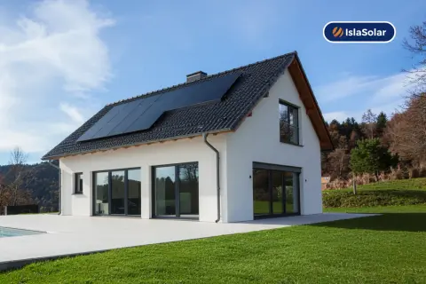 Casa moderna con placas solares en el tejado, ideal para sustituir uralita y generar energía limpia.