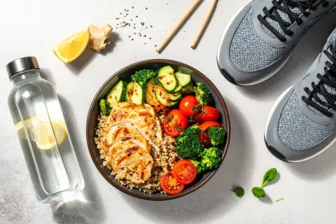 Un repas équilibré pour savoir que manger avant le sport : poulet grillé, quinoa, légumes et eau citronnée. Prêt pour l'effort !