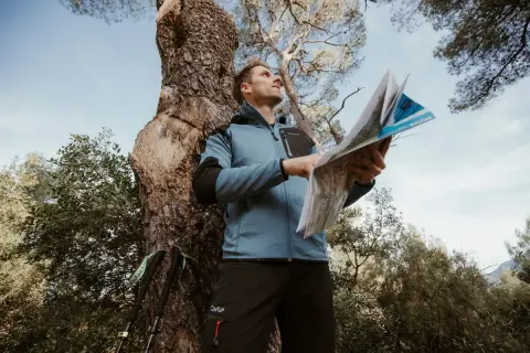 Un randonneur consulte une carte IGN pour s'orienter. C'est quoi une carte IGN ? C'est l'outil indispensable pour explorer la nature.