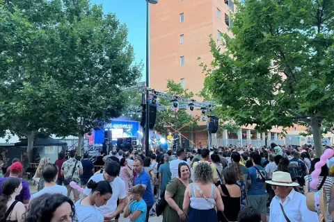 Multitud disfrutando de las fiestas rosales del canal, con un concierto de "Los Gandules" en el escenario.