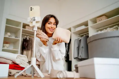 Uśmiechnięta influencerka prezentuje pasek i kosmetyczkę, wyznaczając nowe trendy.