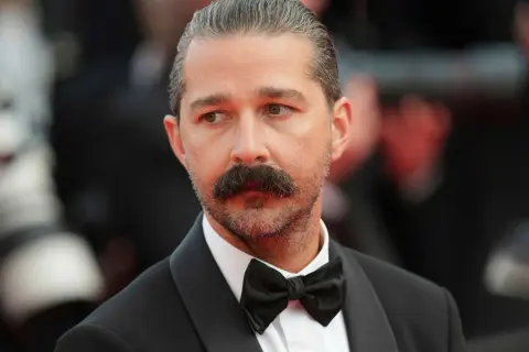 Shia LaBeouf med mustasch och fluga, redo för röda mattan.