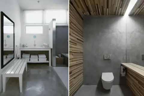 Baño con suelo de hormigón pulido, paredes de microcemento y detalles en madera.