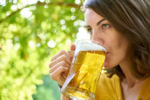 Kobieta pije orzeźwiające piwo z solą w letni dzień.