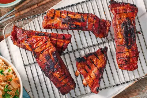 Saftige Rippchen mit glasiertem, karamellisiertem Fleisch auf einem Grillrost. Perfekt für eine rippchen marinade einfach.