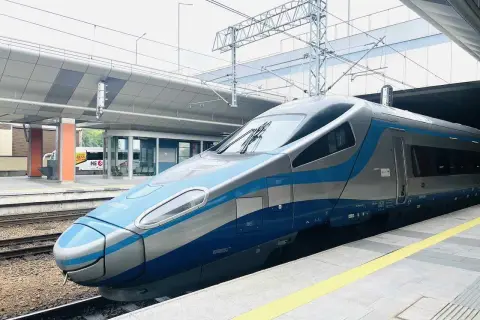 Moderner Zug mit blauen und silbernen Streifen steht am Bahnsteig. Vielleicht der Nachtzug nach Danzig?