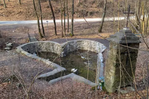 Kamienny, sercowaty basen z wodą i krzyżem obok, przypominający diabelski most w Czarnej.