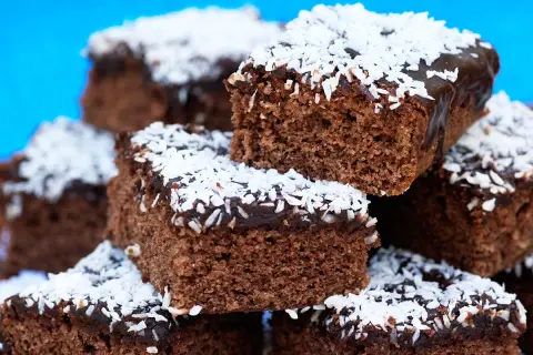 En hög med saftiga kärleksmums utan mjölk, toppade med chokladglasyr och kokosflingor.