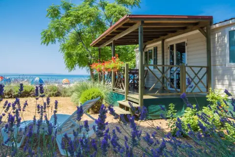 Idealne miejsce, gdzie na wakacje z dziećmi: domek przy plaży, leżaki i lawenda.
