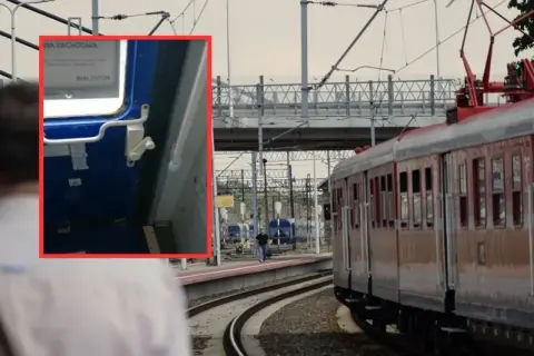 Zbliżenie na mechanizm drzwi pociągu, pokazujący, jak otworzyć drzwi w pociągu, z widokiem na peron i tory.