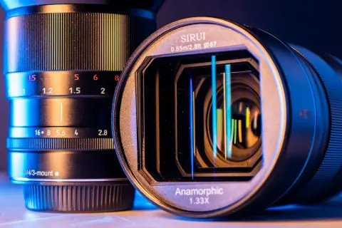 Dwa obiektywy, jeden z oznaczeniem "Anamorphic 1.33X", pokazują, czym jest obiektyw anamorficzny i jego możliwości.