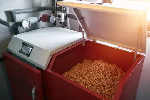Pelletlager für Heizung: Die Frage, wie lange kann man Pellets lagern, ist wichtig. Hier sind sie in einem großen Behälter bereit für die Heizsaison.