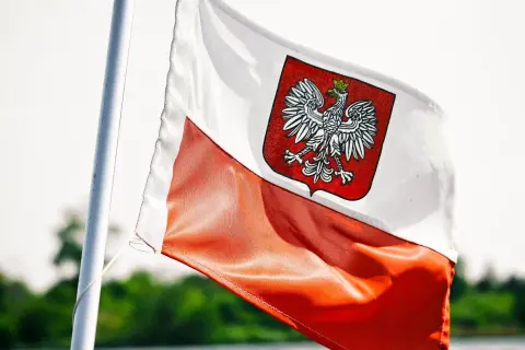 Flaga Polski z orłem, symbol wolności i niezależności. W tle zieleń, jak w kraju, gdzie zagraniczne banki w Polsce rozwijają skrzydła.