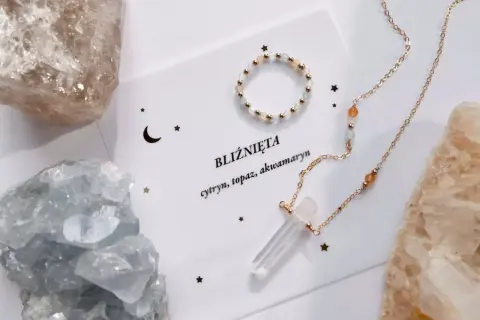 Delikatna biżuteria z kamieni naturalnych, w tym cytrynu i akwamarynu, otoczona surowymi kryształami. Idealny zestaw dla bliźniąt, symbolizujący ich unikalną więź.