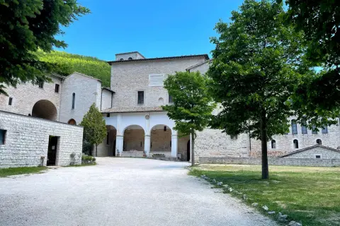 Cortile di un antico complesso monastico in pietra, con un portico ad archi. Ideale per chi cerca la fonte avellana come arrivare.