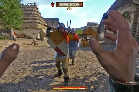 Gracz w Kingdom Come Deliverance, w środku wioski, przygotowuje się do walki. Widok z pierwszej osoby, jakbyś szukał kingdom come deliverance solucja.