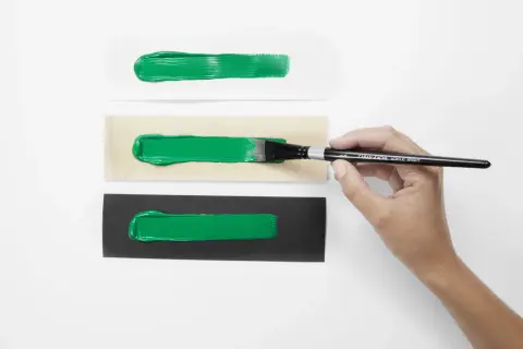 Pennello stende vernice acrilica su carta bianca, legno e nera. La vernice acrilica a cosa serve? A creare effetti vibranti su diverse superfici.