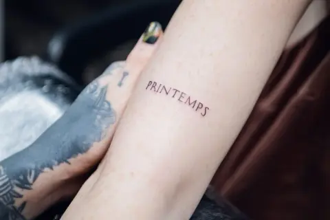 Delikatny napis "Printemps" na przedramieniu to fajne miejsce na tatuaż dla dziewczyny.