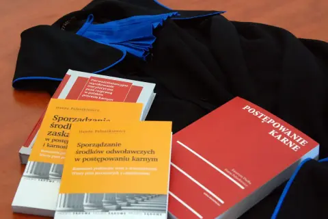 Książki prawnicze o postępowaniu karnym i sporządzaniu środków odwoławczych leżą obok tog. Czy rozprawa może się odbyć bez oskarżonego?