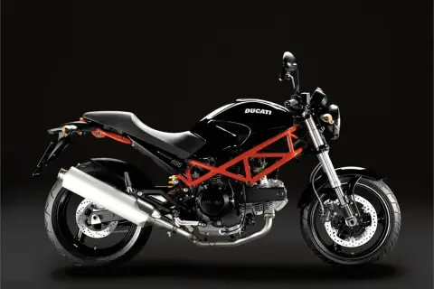 Ducati Monster 695 ficha técnica: una moto negra con chasis tubular rojo, asiento negro y escape plateado, lista para la carretera.