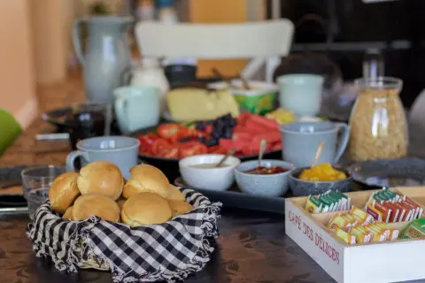 Frukostbuffé med korg full av nybakade scones över natten, frukt, ost och te.