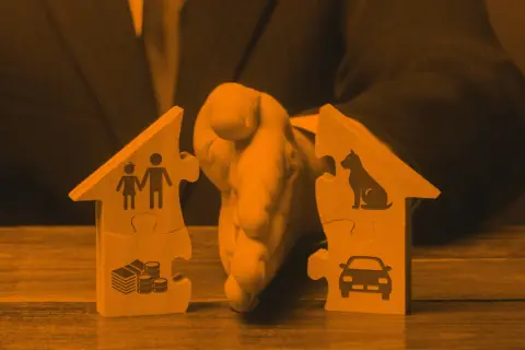 Drewniane puzzle w kształcie domów podzielone na dwie części, symbolizujące podział majątku.