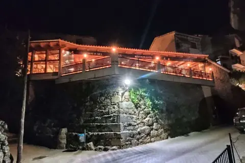 Restaurante Botavara San Jose, iluminado por la noche, con escaleras de piedra y una vista acogedora.