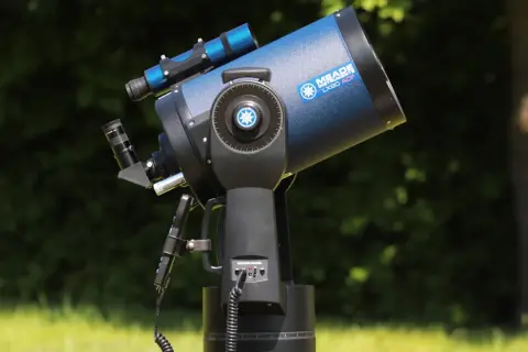 Niebieski teleskop Meade LX90 ACF na montażu, na tle zieleni.