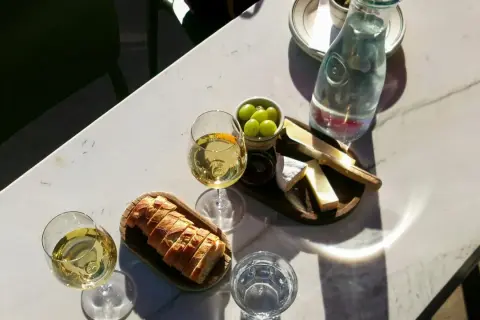 Dwa kieliszki białego wina, idealne do deski serów i pieczywa. Może to być orzeźwiające grenache wino.