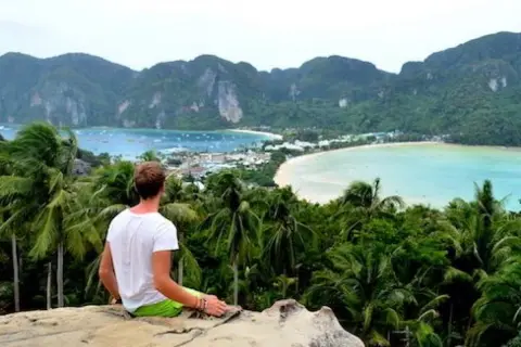 Mann genießt atemberaubenden Blick auf Bucht in Thailand. Tolle Thailand Urlaub Tipps für unvergessliche Momente.
