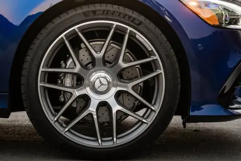 Primo piano della ruota di un'auto blu con cerchi AMG e dischi freno forati, per un controllo freni auto impeccabile.