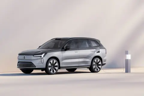 En silverfärgad elbil laddas vid en laddstation. Undrar du vad kostar en ny bil? Denna Volvo ser futuristisk ut.