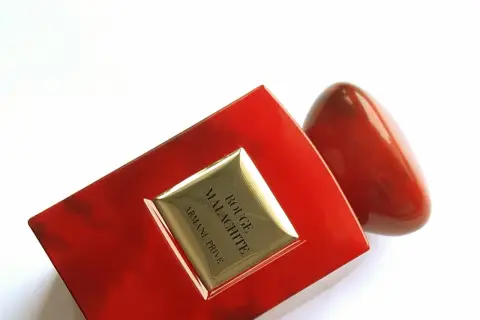 Luksusowe perfumy Armani Privé Rouge Malachite w czerwonym, błyszczącym flakonie, przypominającym kamień.