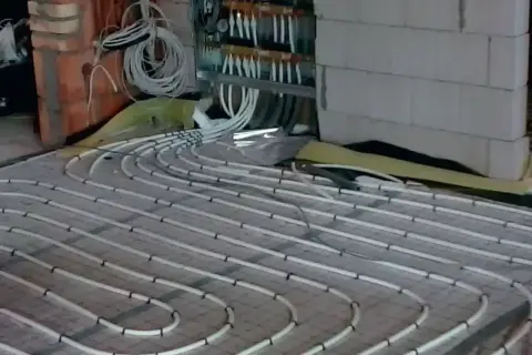 Instalacja ogrzewania podłogowego na 150m2. Czy pompa z kotła wystarczy? Widać rozdzielacz i rury.