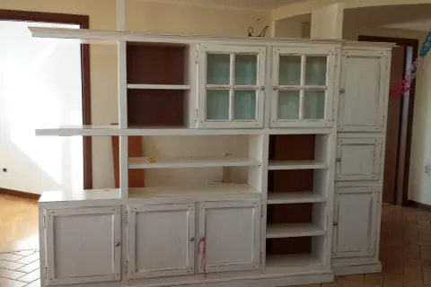 Mobile libreria decapato, con ante a vetro e vani a giorno. Il suo significato è un mobile con finitura effetto invecchiato.