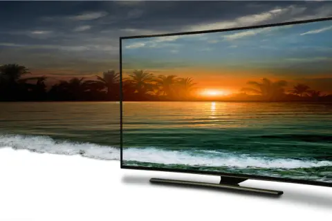 Zachód słońca na plaży z palmami, wyświetlany w jakości 4k full hd na zakrzywionym ekranie telewizora.