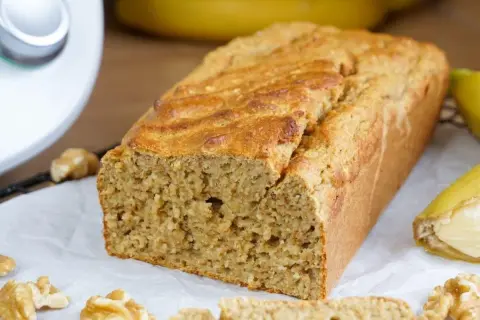 Saftiges Bananenbrot, frisch gebacken mit dem Thermomix. Nüsse und Bananen garnieren das köstliche Gebäck.