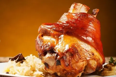Soczysta golonka pieczona, podana z kapustą i musztardą. Idealna marynata do golonki sprawia, że mięso jest kruche i aromatyczne.