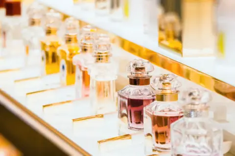 Eleganckie flakoniki z płynami w odcieniach różu i złota, kuszą obietnicą najpiękniejsze perfumy świata.