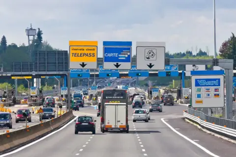 Autostrada we Włoszech z punktem poboru opłat, znakami Telepass, Carte i symbolami płatności.