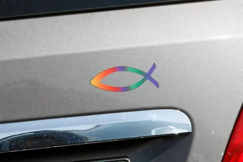 Bunter Fisch-Aufkleber auf einem Auto. Ob katholisch oder evangelisch, dieser Fisch symbolisiert Glauben.