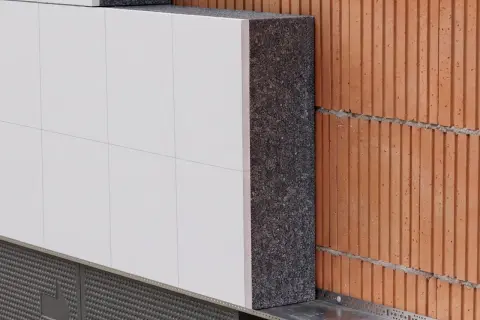 Warstwa styropianu między cegłą a białym tynkiem. Czy styropian wygłusza? Tak, doskonale izoluje akustycznie i termicznie.
