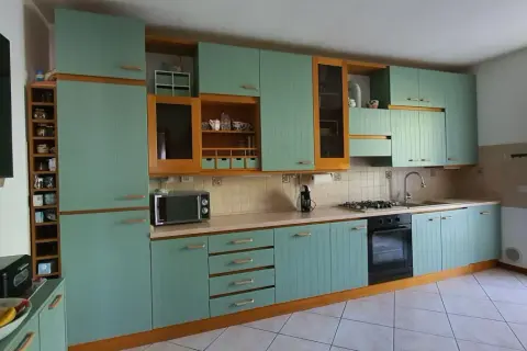 Cucina con ante azzurre e finiture in legno. Si pensa a come cambiare colore ante cucina per un look più moderno.