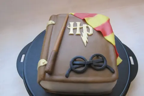 En tårta formad som en bok med Harry Potters trollstav, glasögon och Gryffindors halsduk. Ett magiskt harry potter tårta recept!