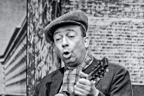 Stanisław Grzesiuk śpiewa, grając na mandolinie. Jego charakterystyczne utwory niosą echo warszawskiej Pragi.