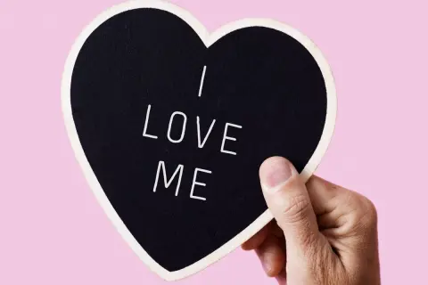 Dłoń trzyma serce z napisem "I LOVE ME". To jak piękne krótkie wiersze o miłości, zaczynające się od siebie.