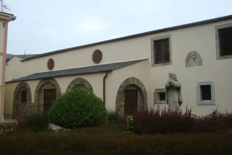 Fachada del convento de Santa Clara en Ribadeo, con arcos de piedra, ventanas y una estatua de monja.