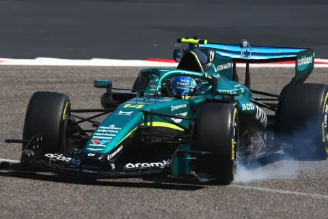 Coche Aston Martin verde en pista, humeando al girar. Un momento de pura adrenalina en el mundial F1.