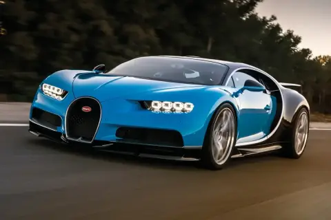 Niebieski Bugatti Chiron pędzi po drodze. Marzenie o takim aucie, choć jego bugatti cena jest astronomiczna, jest dla wielu.