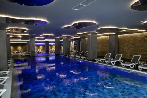 Nowoczesny basen w hotelu dla dorosłych w Polsce. Luksusowe leżaki i nastrojowe oświetlenie tworzą idealną atmosferę relaksu.